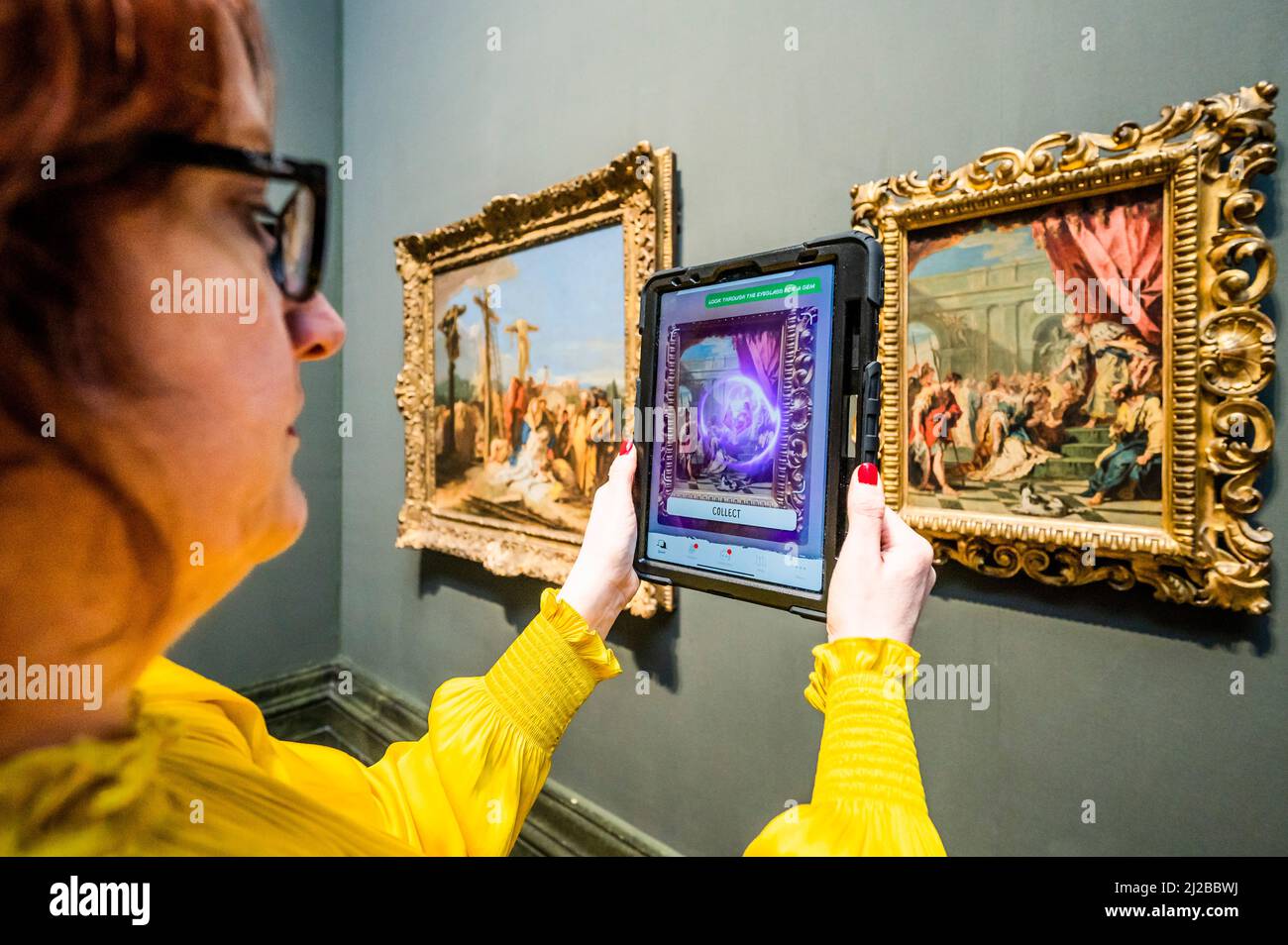 London, Großbritannien. 31. März 2022. Die Mitarbeiter der Galerie testen das System, indem sie mit Hilfe von animierten „Keepers“ – dem „Keeper of Paintings“ und der „Palette of Perception“-Familienspur-App in der National Gallery – nach Informationen suchen und Juwelen sammeln, während sie ihre erste immersive Augmented Reality-App startet, die mit Hilfe von Over erstellt wurde 70 Kinder rechtzeitig zu den Osterferien. Es handelt sich um eine kostenlose mobile Erfahrung, die AR-Technologie nutzt und Kinder dazu ermutigt, die Galerie zu erkunden und mehr über ihre Gemälde zu erfahren. Kredit: Guy Bell/Alamy Live Nachrichten Stockfoto