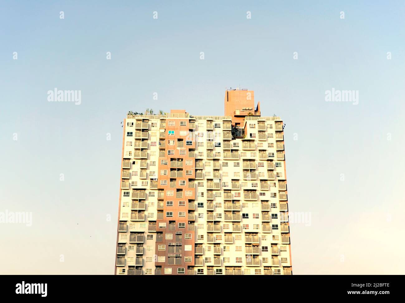 Wunderschöne, kosmopolitische Wohnanlage, Eigentumswohnung oder moderne, flache Gebäudestruktur mit pastellblauer Skyline. Stockfoto