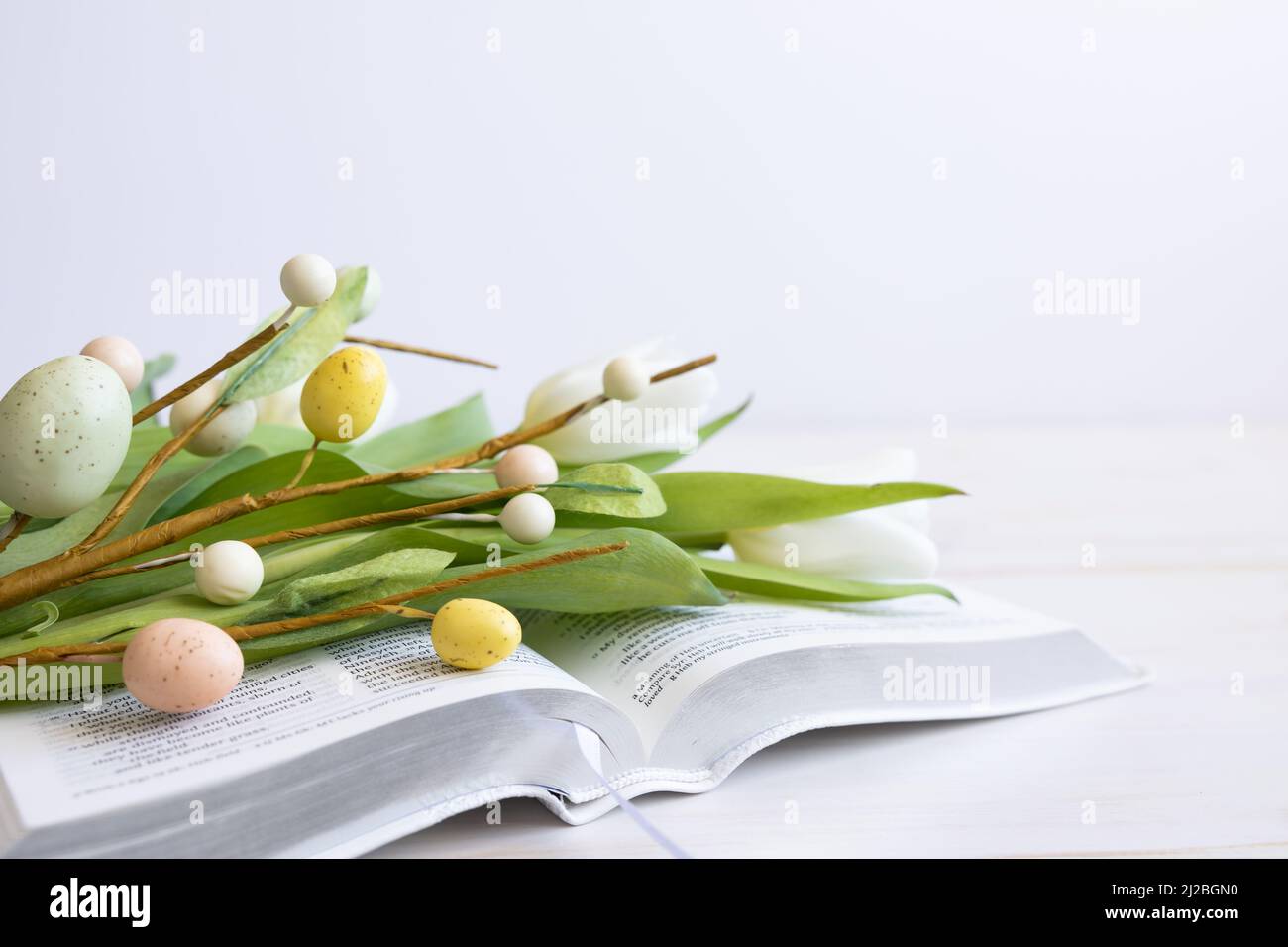 Weiße bibel mit weißen Tulpen und ostereier-Dekorationen auf weißem Holz mit Kopierraum Stockfoto