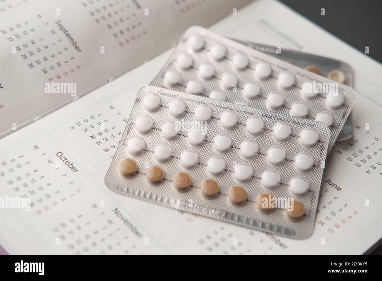 Geburtenkontrolle Pillen, Kalender und Notizblock auf dem Tisch Stockfoto