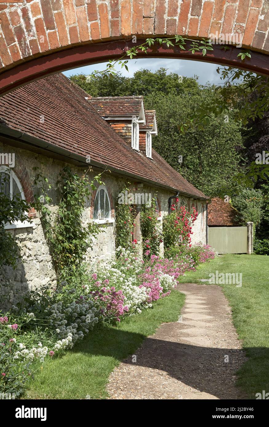 Rose Covered Cottages durch Bogen genommen Stockfoto