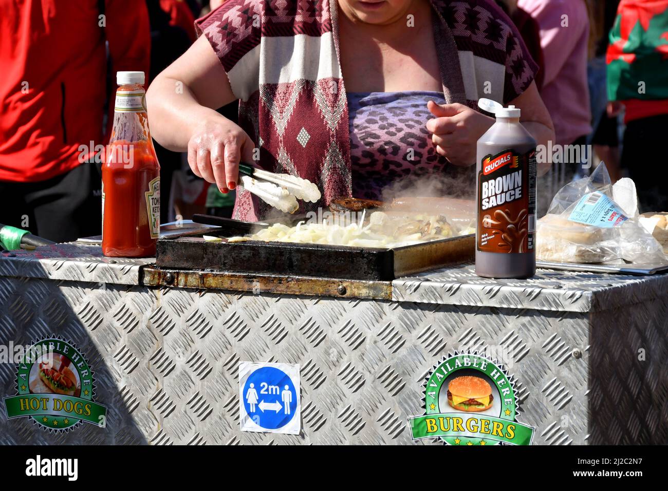 Cardiff, Wales - 2022. März: Person, die Burger und Zwiebeln auf einer mobilen Lebensmitteleinheit in einer Straße im Stadtzentrum von Cardiff kocht Stockfoto