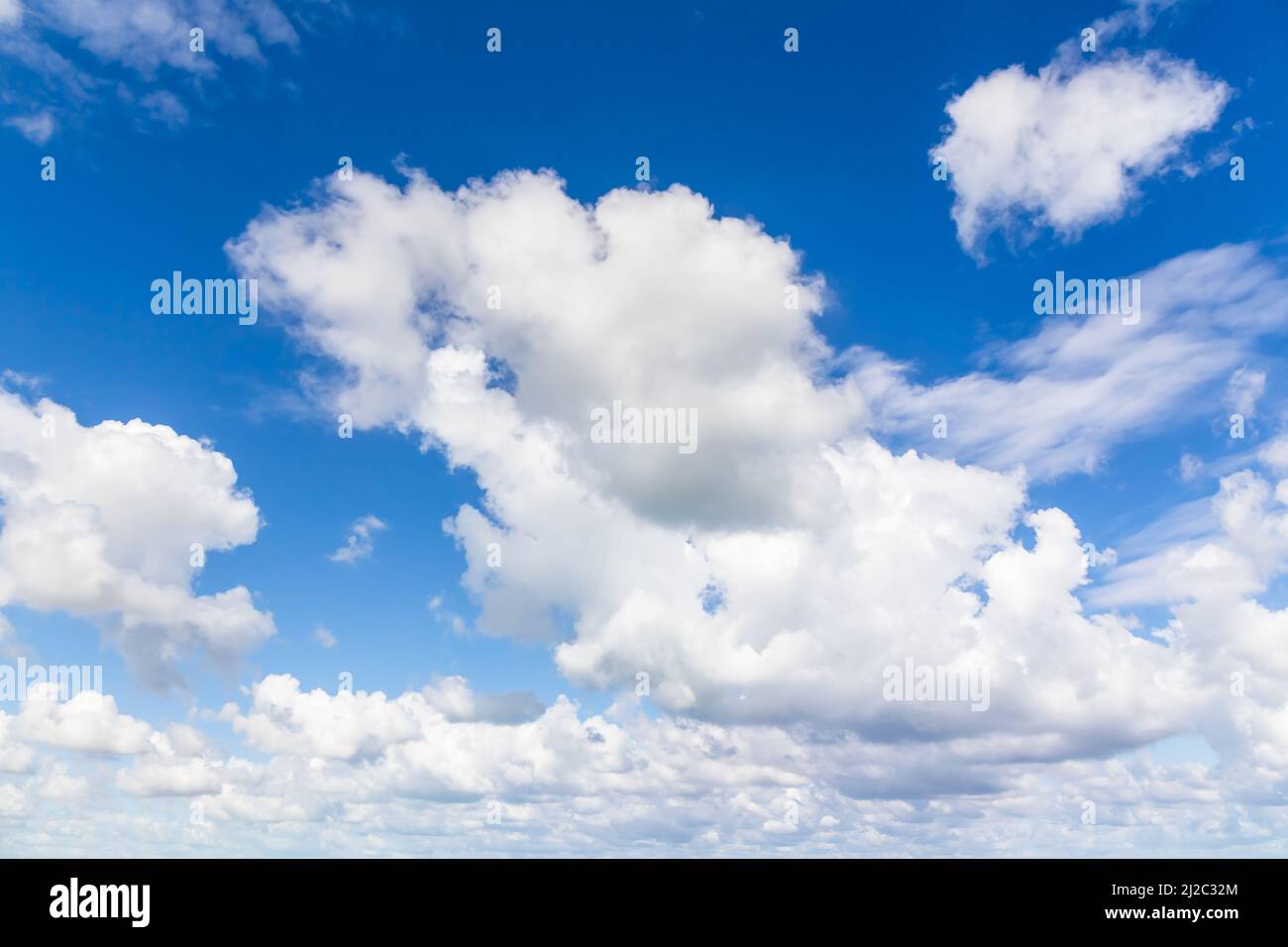 Blauer Himmel mit weißen Wolken am Tag. Cumulus und Altocumulus Arten von Wolken. Natürliches Hintergrundfoto Stockfoto