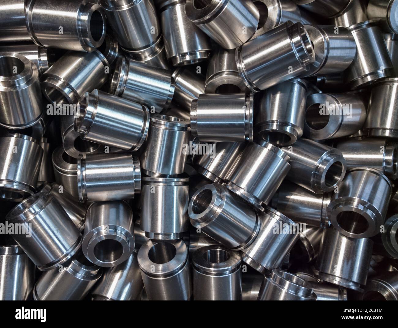 Viele kleine gleich glänzende Stahlteile flacher Hintergrund. Rohe Metalloberfläche nach cnc, die Licht wie Silber dreht Stockfoto