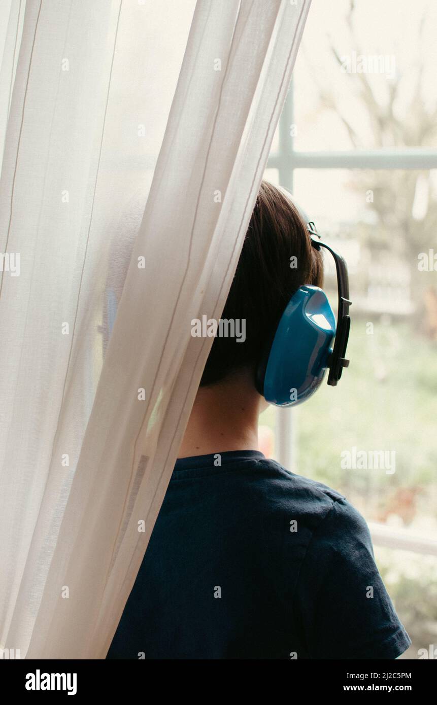 Junge, die Kopfhörer mit Geräuschminimierung verwenden Stockfoto