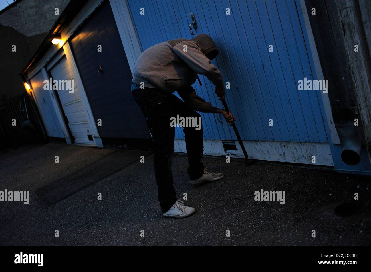 Ein Einbrecher versucht, eine Tür aufzubrechen. Stockfoto