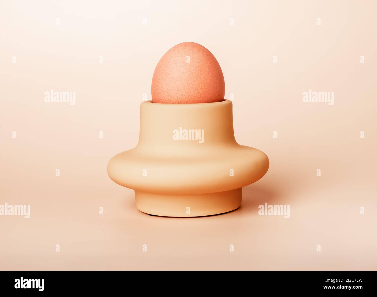 Gekochtes Ei in Tasse, Halter oder Server auf beigem Hintergrund. Ostern oder nahrhafte Bauernhof Produktkonzept. Frühstück. Hochwertige Fotos Stockfoto