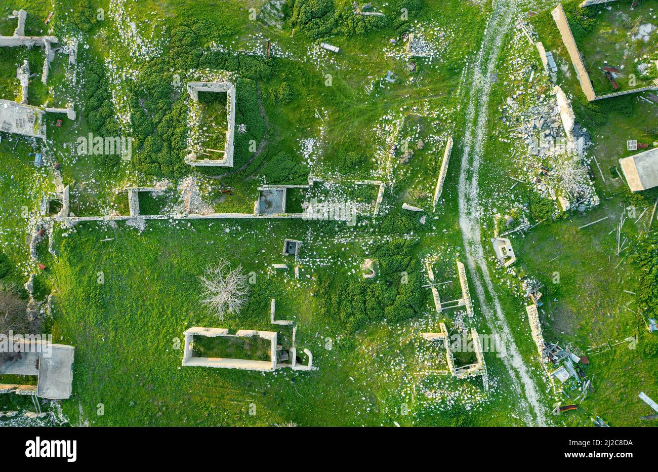 Verlassene traditionelle Dorf mit Ruinen von Häusern und unbefestigte Straße, Blick von oben Stockfoto