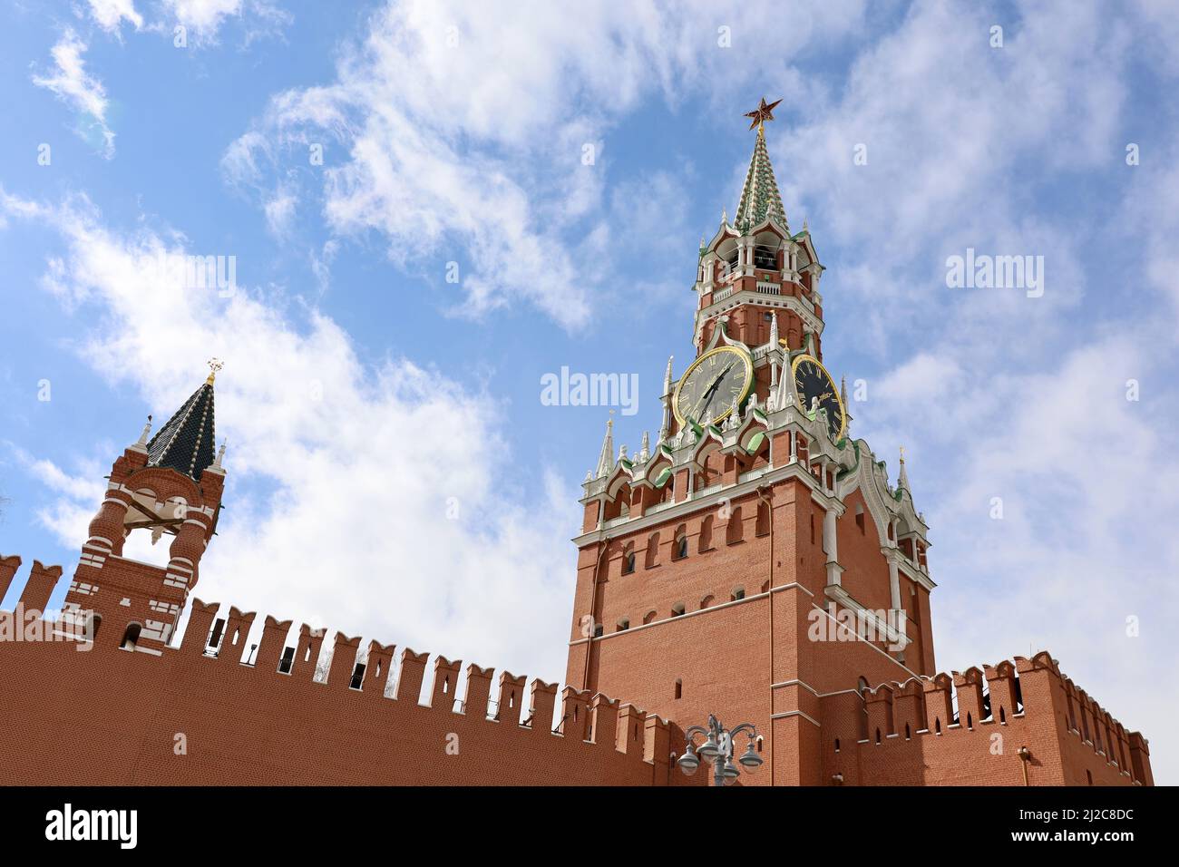 Moskauer Kreml Turm und Ziegelmauer auf blauem Himmel und weißen Wolken Hintergrund. Glockenspiel des Spasskaya-Turms, Symbol Russlands auf dem Roten Platz Stockfoto