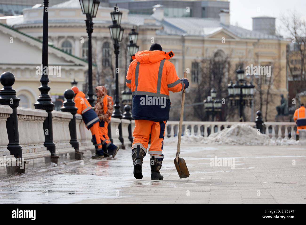 Arbeiter während der Straßenreinigung. Hausmeister mit Schaufeln, Schneeräumung in der Frühlingsstadt Stockfoto