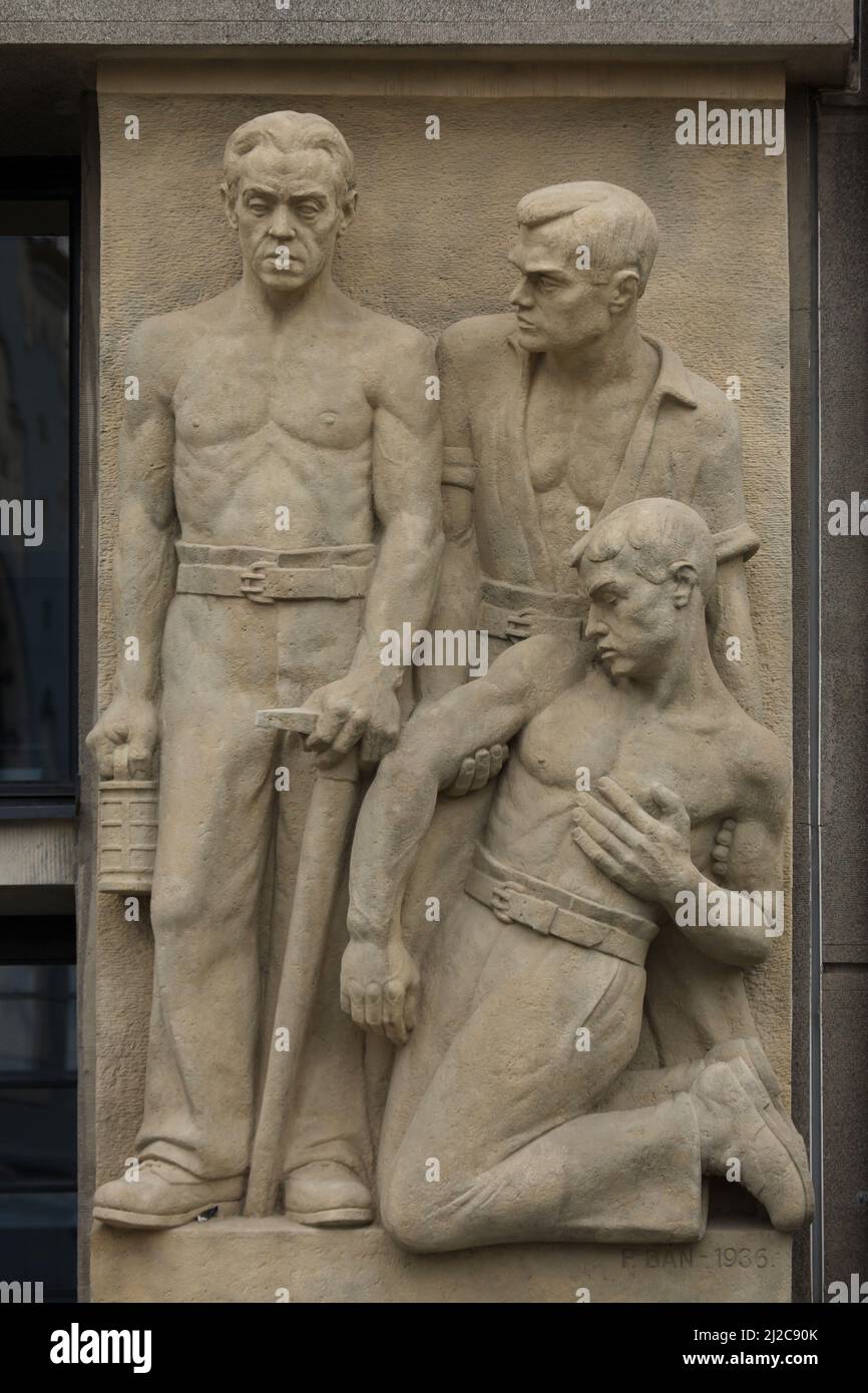 Verletzte Bergarbeiter auf dem Relief des slowakischen modernistischen Bildhauers Pavol Bán (1936) auf dem Gebäude der Arbeitersozialversicherungsgesellschaft (Robotnícka sociálna poisťovňa) in Bratislava, Slowakei. Stockfoto