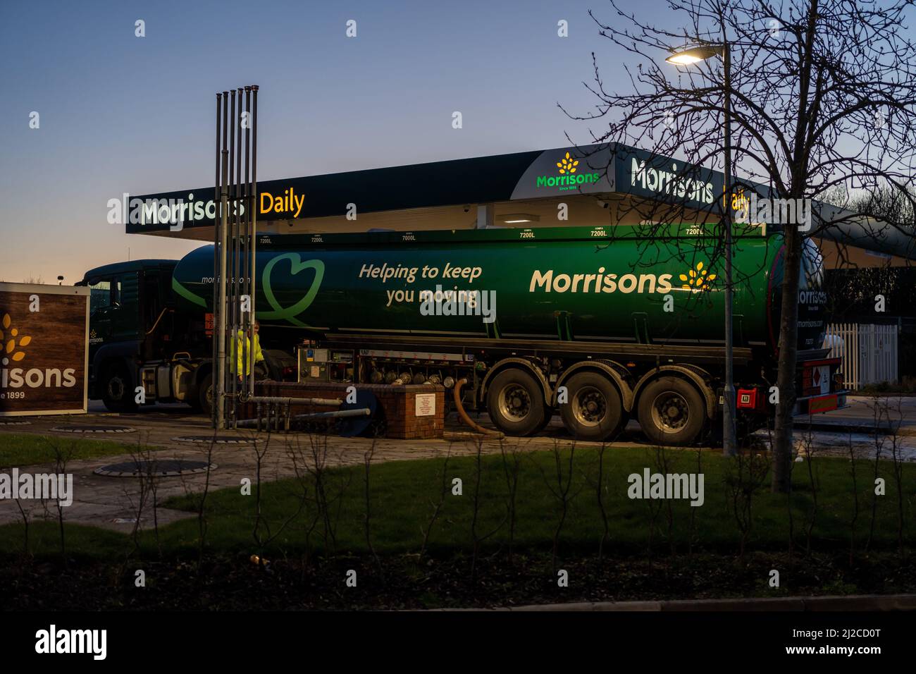 Ein Tanker betankt Morrisons Tankstelle, Boroughbridge Services, North Yorkshire, Großbritannien, bei Abendlicht. Stockfoto