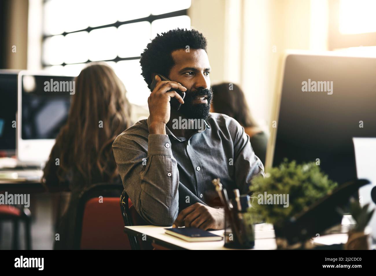 Treffen wir uns, dann können Sie Ihre Ideen teilen. Aufnahme eines Geschäftsmannes, der am Telefon sprach, während er an seinem Schreibtisch saß. Stockfoto