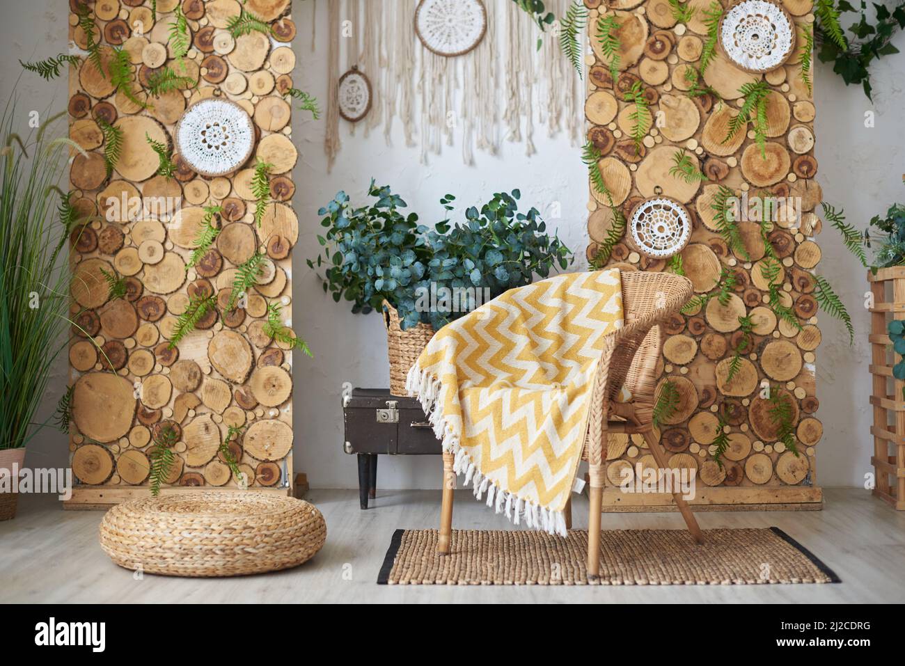 Boho-Wohnzimmerdesign und Korbsessel mit Karo Stockfoto