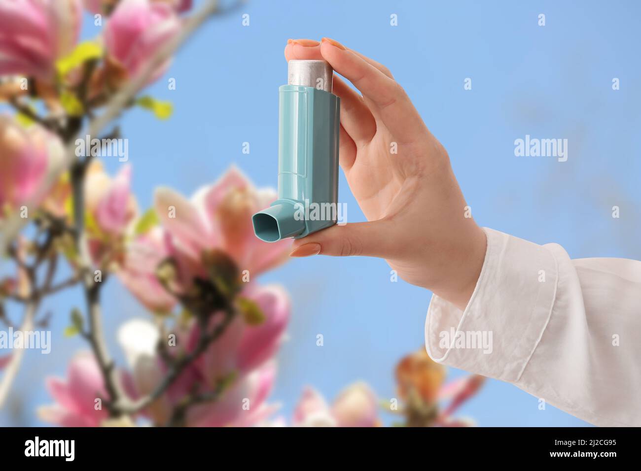 Junge Frau mit Inhalator im Freien am Frühlingstag, Nahaufnahme Stockfoto