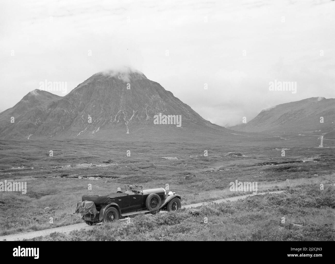 Auto in hügeliger Landschaft mit tief hängenden Wolken ca.: 1930s-1950s Stockfoto