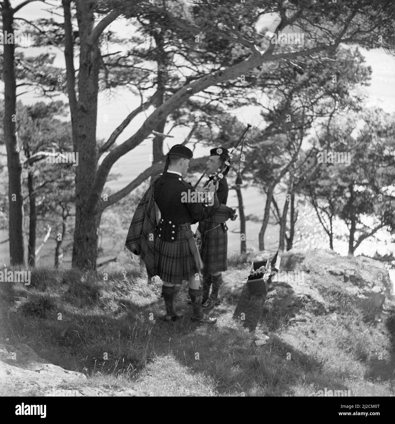 Zwei Dudelsackspieler stimmen ihre Instrumente bei den Highland Games, einer Fortsetzung traditioneller Clanspiele aus dem schottischen Hochland aus dem 19. Jahrhundert um 1934 Stockfoto