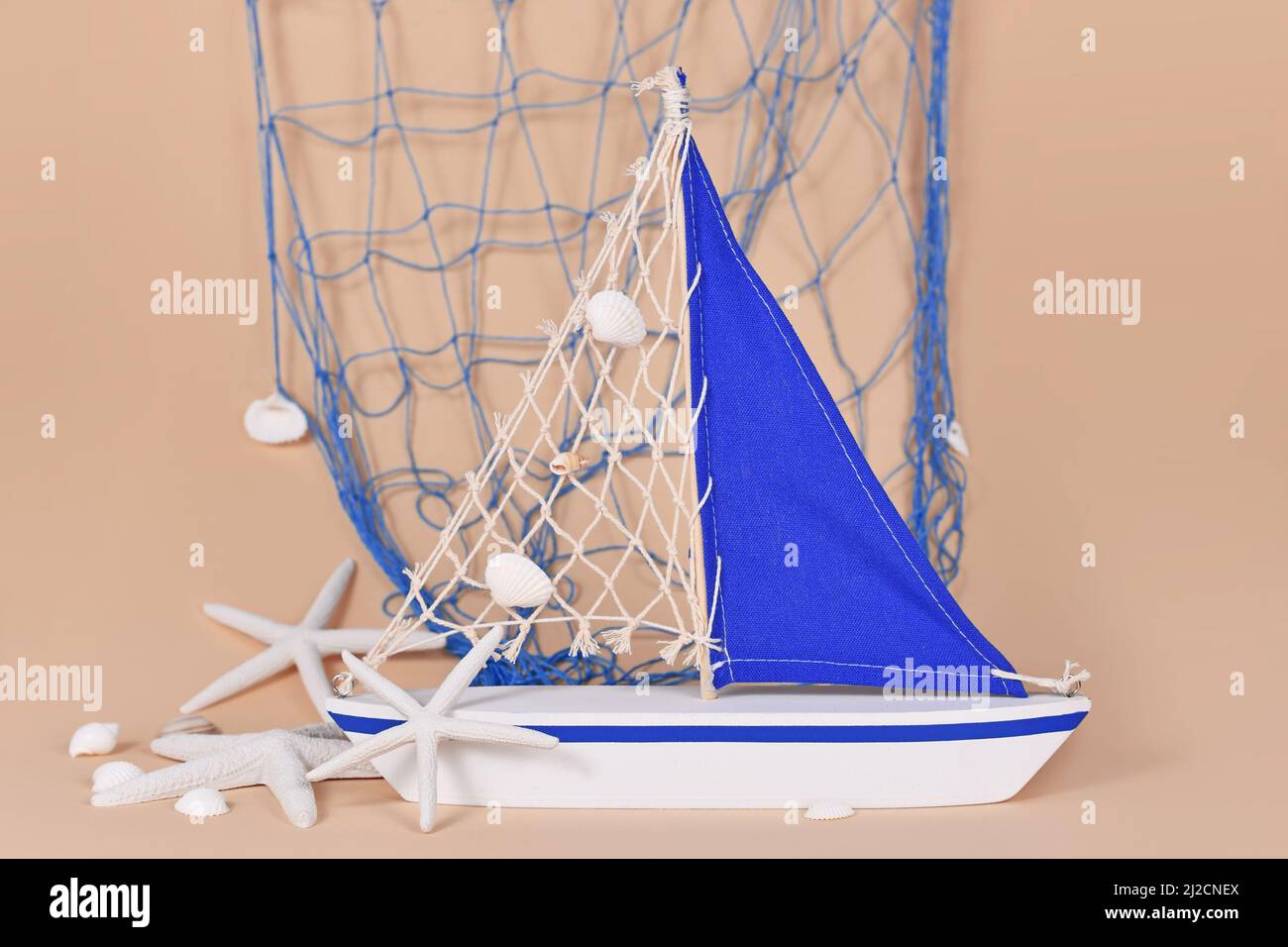 Kleine Segelbootdekoration mit Seesternen und Fischernetz Stockfoto