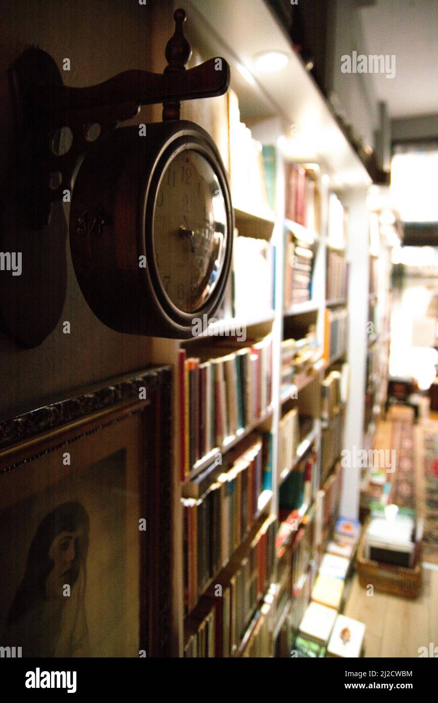 Bibliothek und Zeit, Wanduhr in der Bibliothek Stockfoto