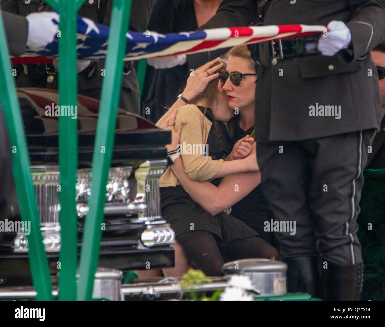 Langhorne, Usa. 31. März 2022. Stephanie Mack, Witwe des Pennsylvania State Troopers Martin Mack III tröstet eine von zwei Töchtern während der Interment-Dienste für den Pennsylvania State Trooper Martin Mack III Donnerstag, 31. März 2022 auf dem Our Lady of Grace Cemetery in Langhorne, Pennsylvania. Mack wurde letzte Woche im Dienst mit seinem Mitstreiter Brendan Sisca am I-95 getötet. Kredit: William Thomas Cain/Alamy Live Nachrichten Stockfoto