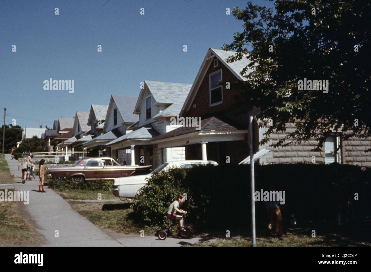 Kinder, die außerhalb von Häusern im 1100 Block der Pacific Avenue in Kansas City, KS, spielen. 1975 Stockfoto