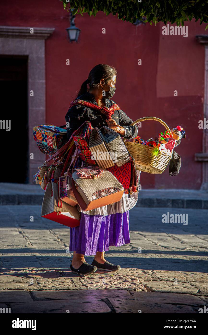 Ein Vender auf einem platz in San Miguel de Allende, Guanajuato, Mexiko, der eine Vielzahl von mexikanischen Volkshandwerken verkauft. Stockfoto