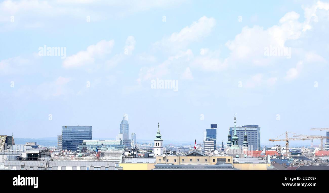 Blick auf das Stadtzentrum von Wien. Gebäude, Dächer, Kraniche und blauer Himmel mit Wolken. Wien, Österreich Stockfoto