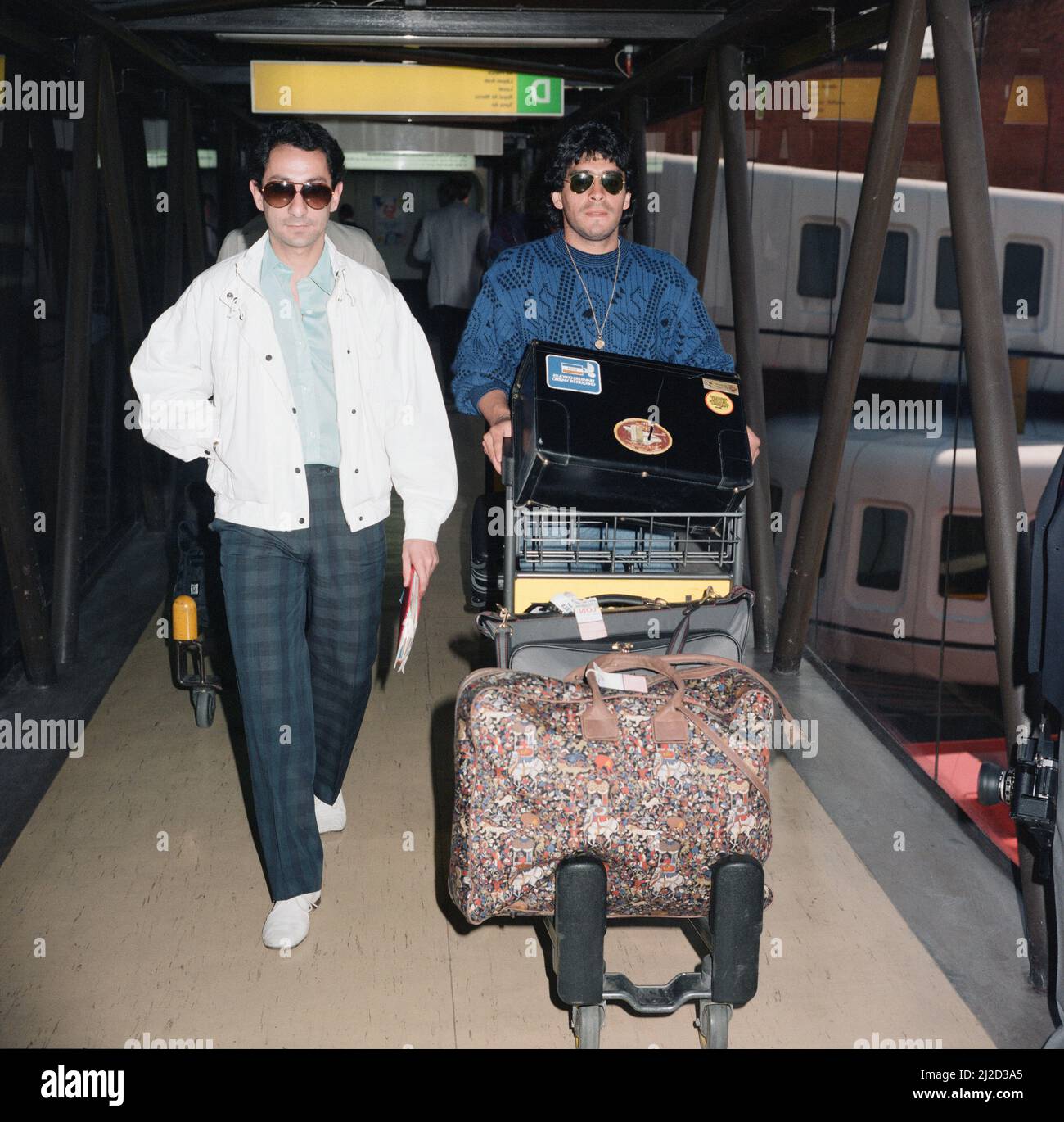 Der argentinische Fußballspieler Diego Maradona wird bei seiner Ankunft in London Heathrow von seinem Freund und internationalen Teamkollegen Osvaldo Ardiles empfangen.Maradona nimmt an diesem Abend am Erfahrungsbericht von Ardiles für Spurs gegen Inter Mailand in der White Hart Lane Teil. 1. Mai 1986. Stockfoto