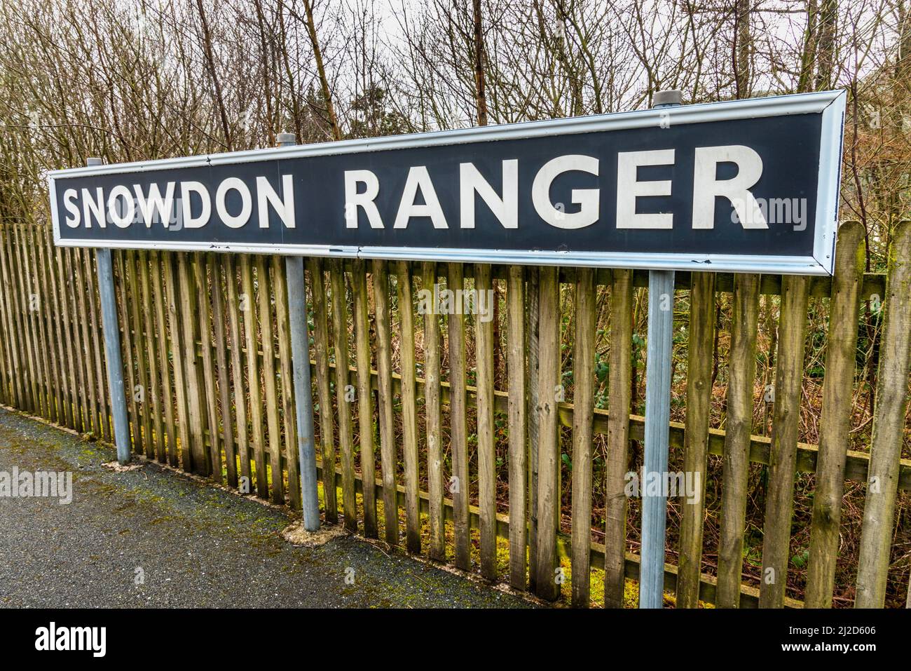 Snowdonia, Wales, UK-March 17. 2022:das Bahnsteigsschild, steht prominent an der kleinen, leeren, walisischen Bergbahnhalt, auf der Route durch Snow Stockfoto