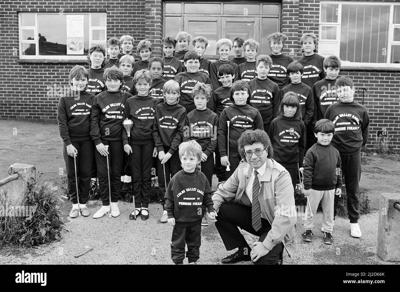 Colne Valley Eagles Majorette-Truppe wird in der nächsten Saison dank eines Geschäftsmannes von Golcar stilvoll aussteigen. Eddie Bailey, ein Partner von Pennine Finance, hat die 45-köpfigen Truppe-Trainingsanzüge gegeben, die sie vor Wettkämpfen tragen werden. Die Truppe ? Und die zweijährige Rebecca Dack ? Das Bild zeigt stolz sein neues Kit für Herrn Bailey. Mr Bailey's Tochter Caroline ist eine Majorette in der Truppe und sein Sohn Lee ist in der Band. 3.. September 1986. Stockfoto