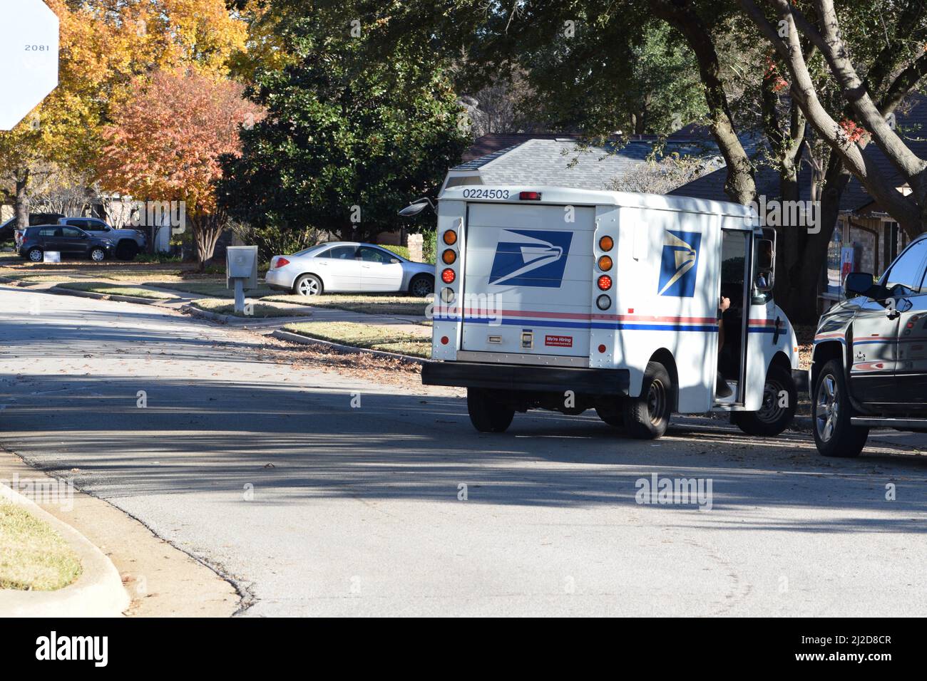 Ein Postbote fährt seinen USPS-Lastwagen durch ein Wohnviertel in Bedford, TX Stockfoto