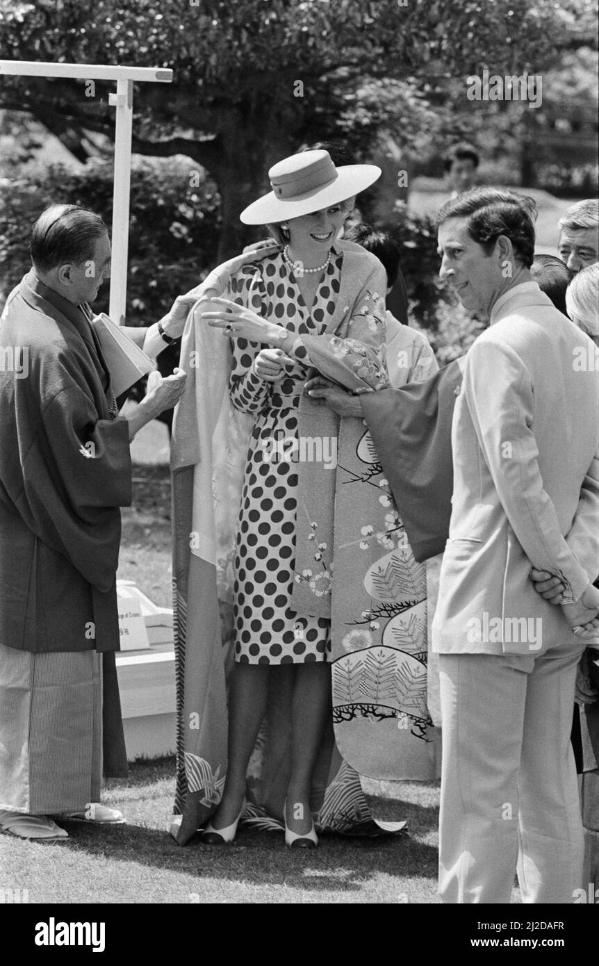 Ihre Königliche Hoheit Prinzessin Diana, die Prinzessin von Wales, wird von Stadtbeamten dabei unterstützt, einen japanischen Kimono während ihrer Tour durch das Nijo Castle in Kyoto, Japan, zu tragen. Prinzessin Diana trug einen roten Hut und ein rot-weiß getupftes Oberteil, wie die japanische Flagge. Als Zeichen des Respekts. Bild aufgenommen am 9.. Mai 1986 Stockfoto