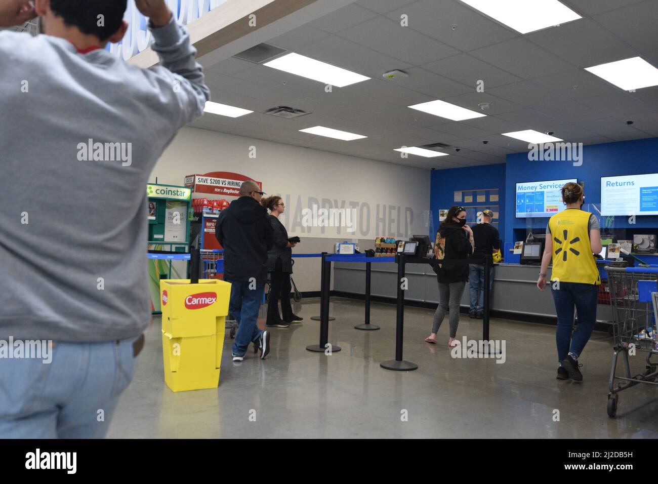 Ein Arbeiter, der in einem Walmart-Geschäft zu einem Kundenservice-Bereich läuft - August 2021 Stockfoto