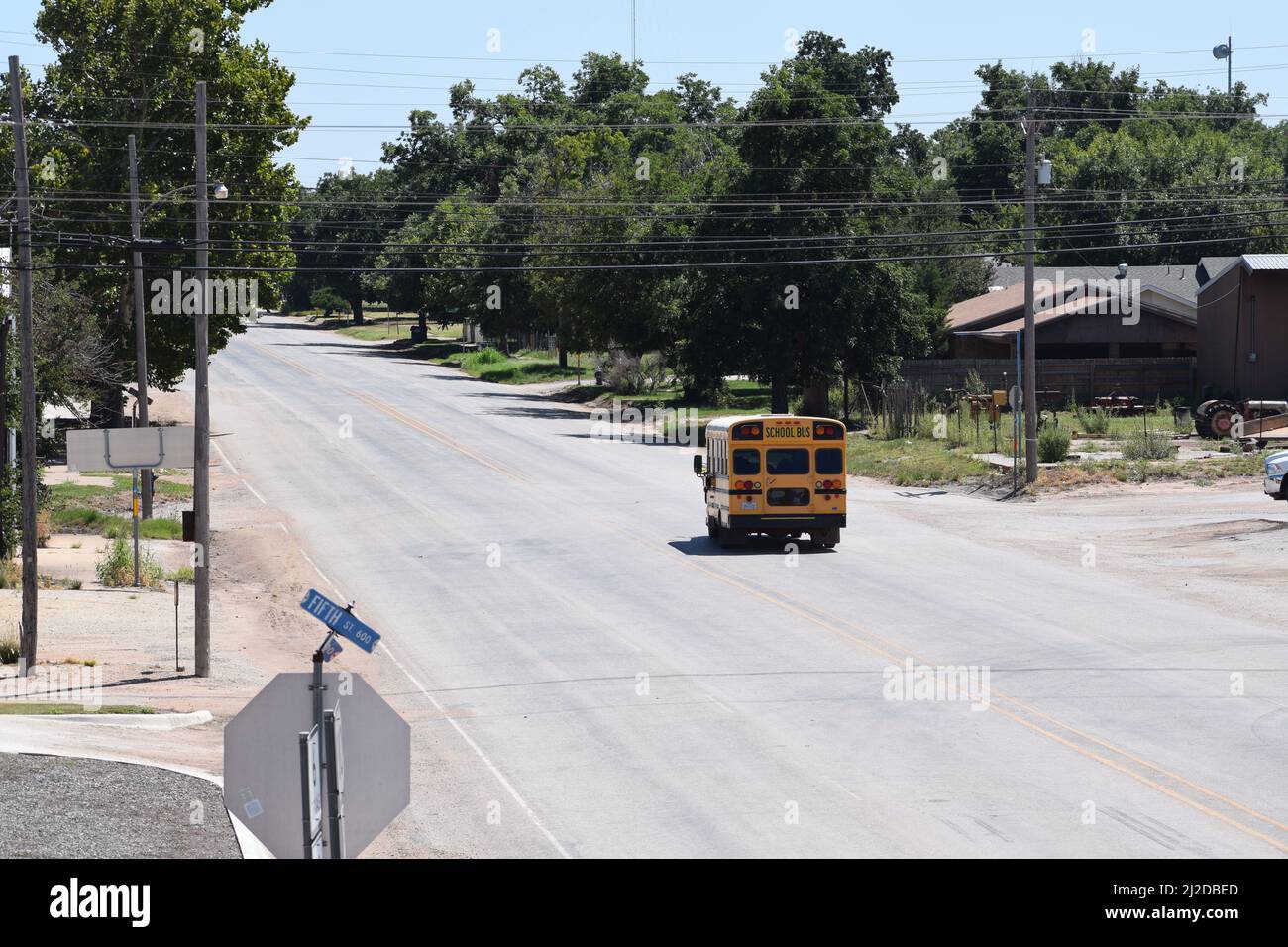 Kurzer gelber Schulbus, der eine Straße in Rule Texas entlang fährt - August 2021 Stockfoto
