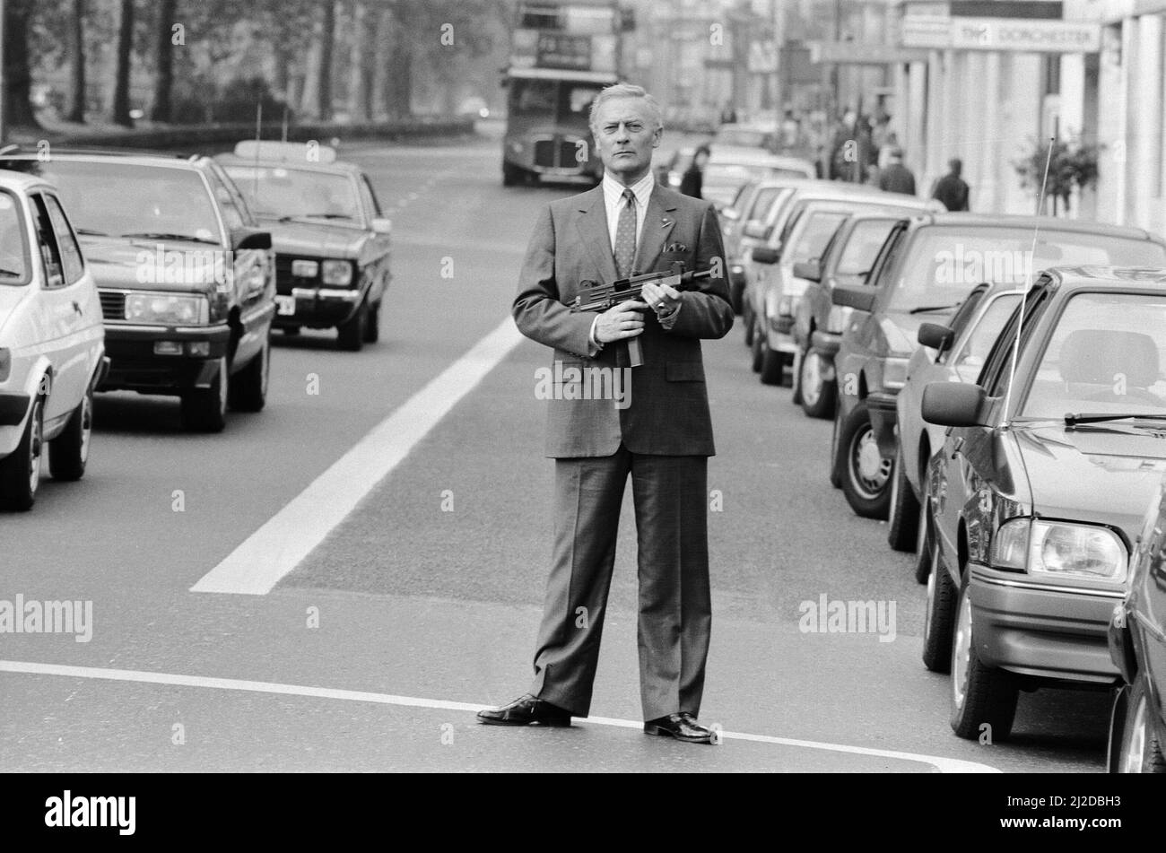 Der britische Schauspieler Edward Woodward, der in der amerikanischen Fernsehserie The Equalizer den Ex-Agenten Robert McCall spielt, posiert in London mit einem Maschinengewehr, um die Serie zu promoten. 25.. Oktober 1986. *** Lokale Bildunterschrift *** Der Equalizer Stockfoto