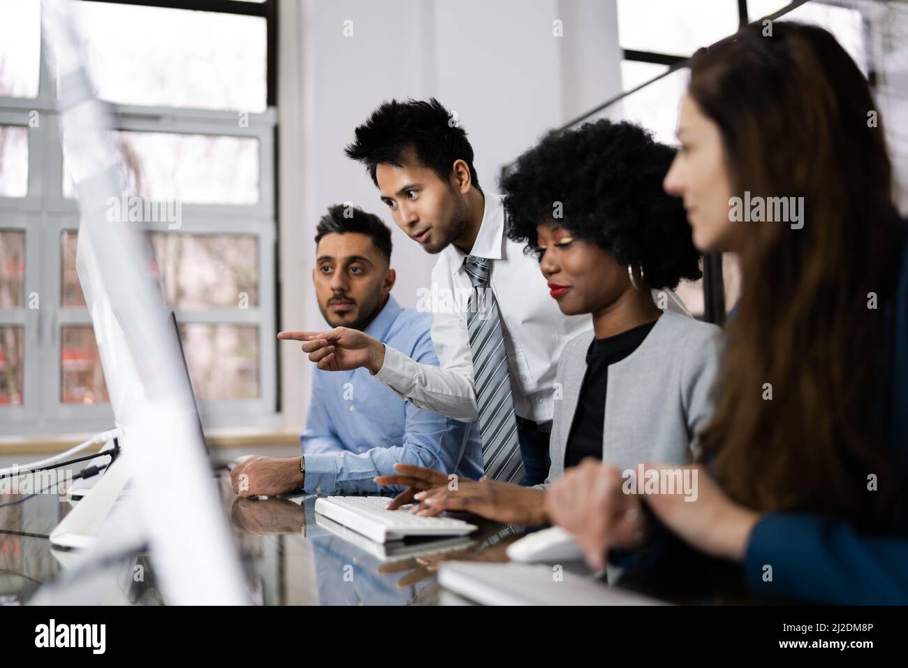 Gruppe von Happy Business Menschen mit Laptop diskutieren am Arbeitsplatz im Büro Stockfoto