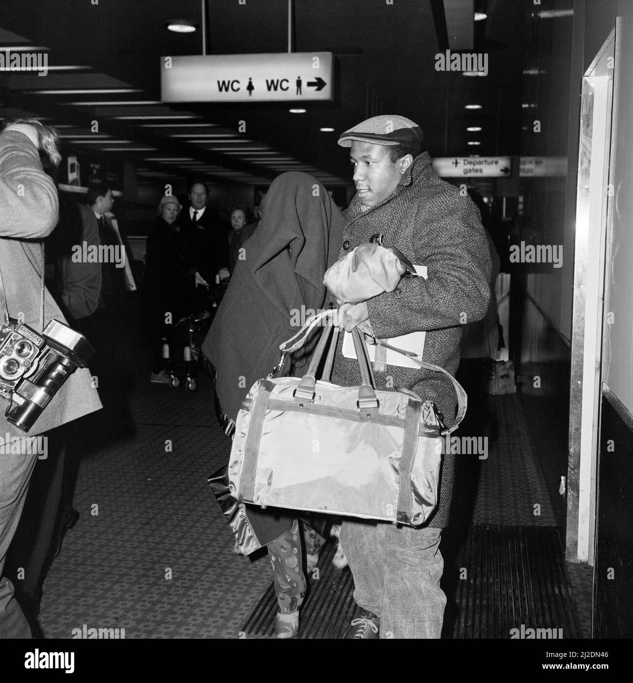 Der amerikanische Pop-Künstler Prince verlässt Großbritannien mit einer Decke über dem Kopf und der Musikerin Wally Safford an seiner Seite.12.. Februar 1985 Stockfoto