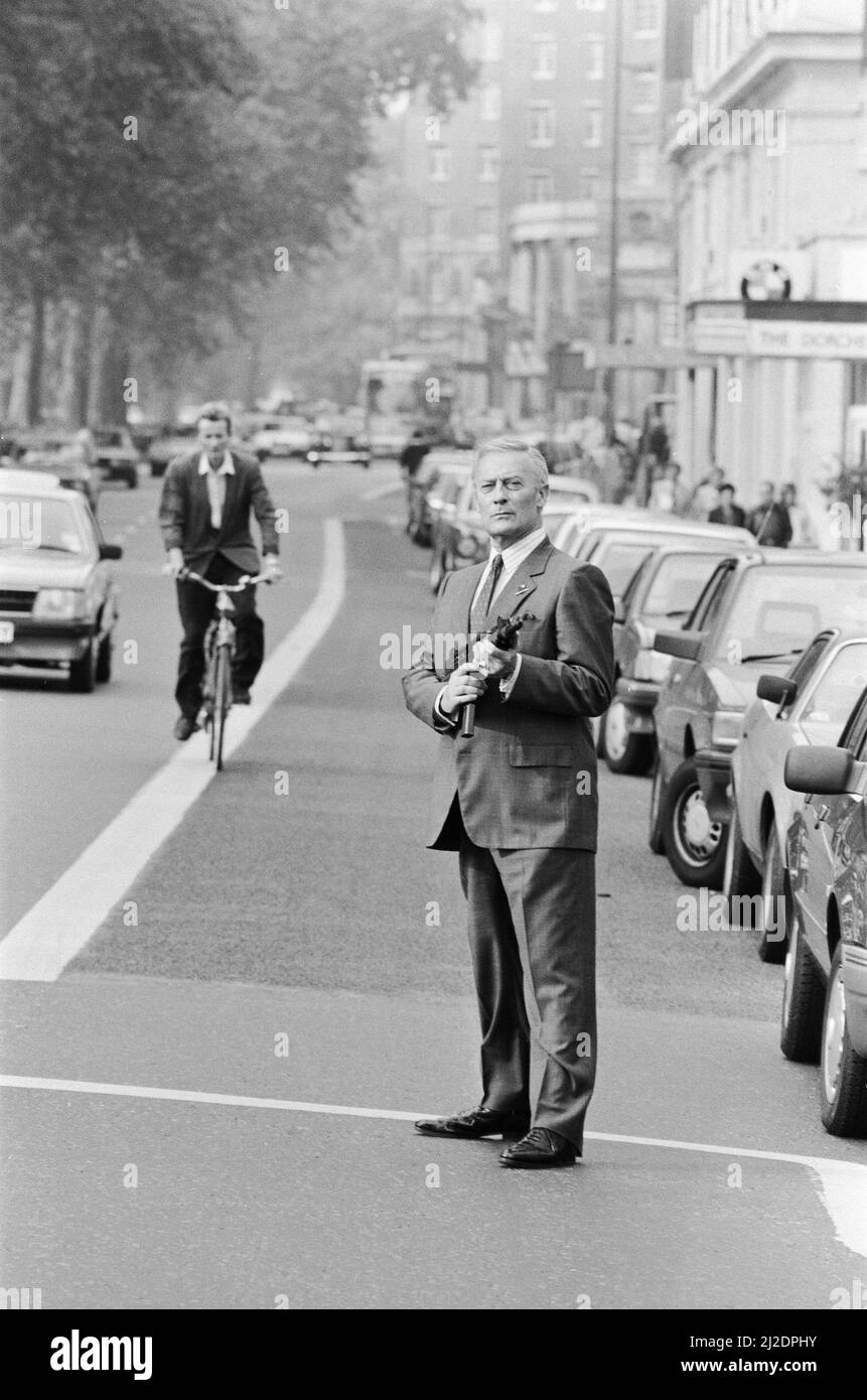 Der britische Schauspieler Edward Woodward, der in der amerikanischen Fernsehserie The Equalizer den Ex-Agenten Robert McCall spielt, posiert in London mit einem Maschinengewehr, um die Serie zu promoten. 25.. Oktober 1986. *** Lokale Bildunterschrift *** Der Equalizer Stockfoto
