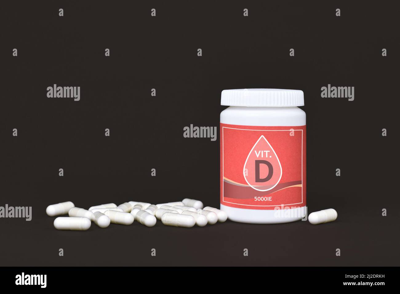 Vitamin D Nahrungsergänzungsmittel mit Behälter mit Pillen auf dunklem Hintergrund Stockfoto