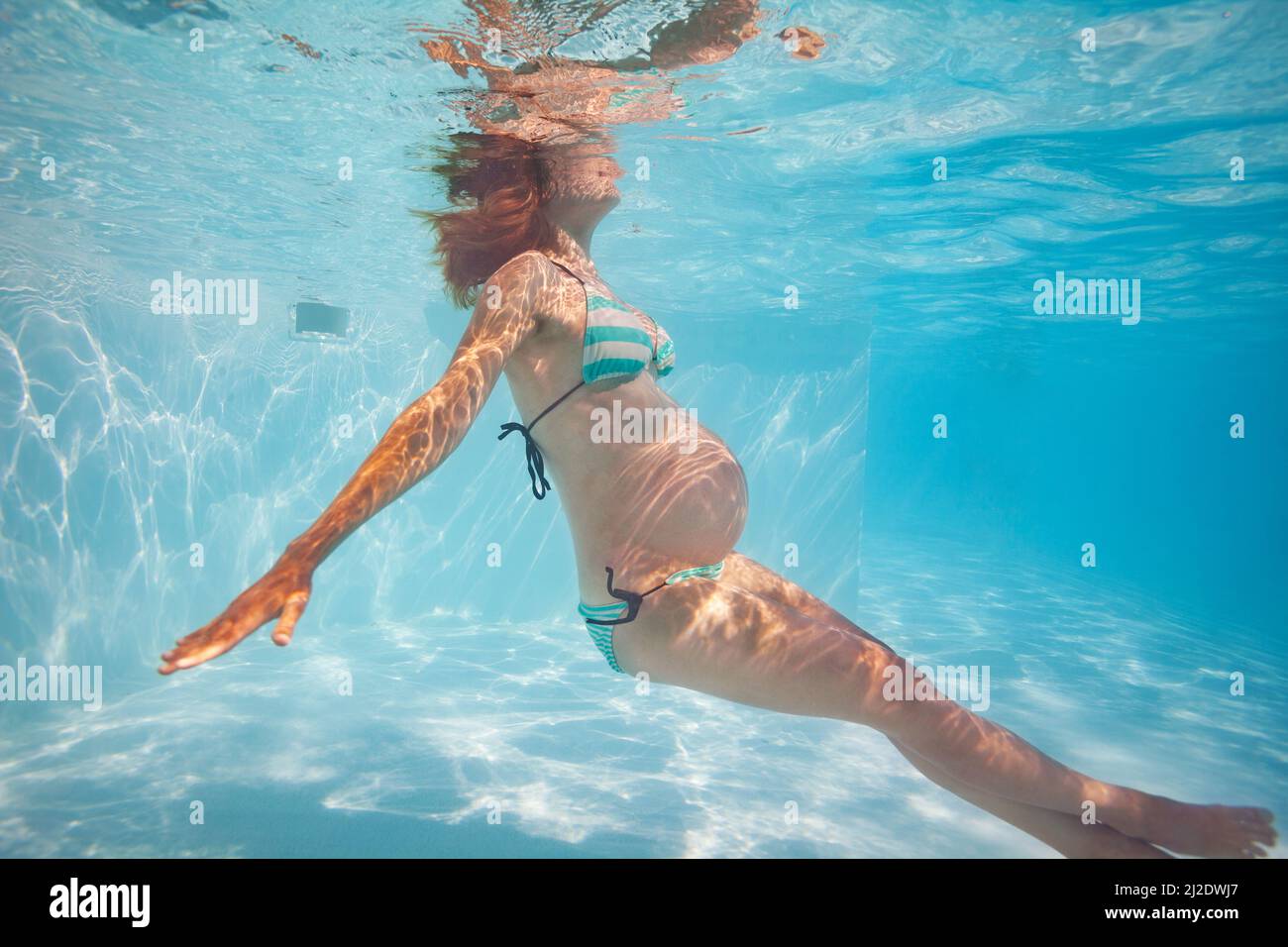 Schwanger Frau Übung im Außenpool unter Wasser Stockfoto