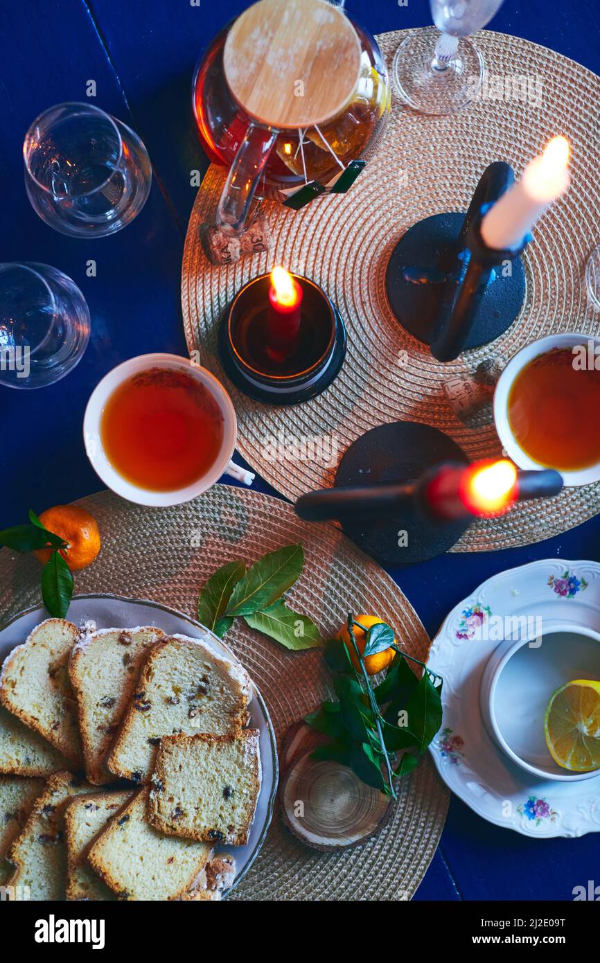 Festliche Stillleben von Tee, Kuchen, Mandarinen und Kerzen. Heiligabend und Silvester. Flach liegend. Stockfoto