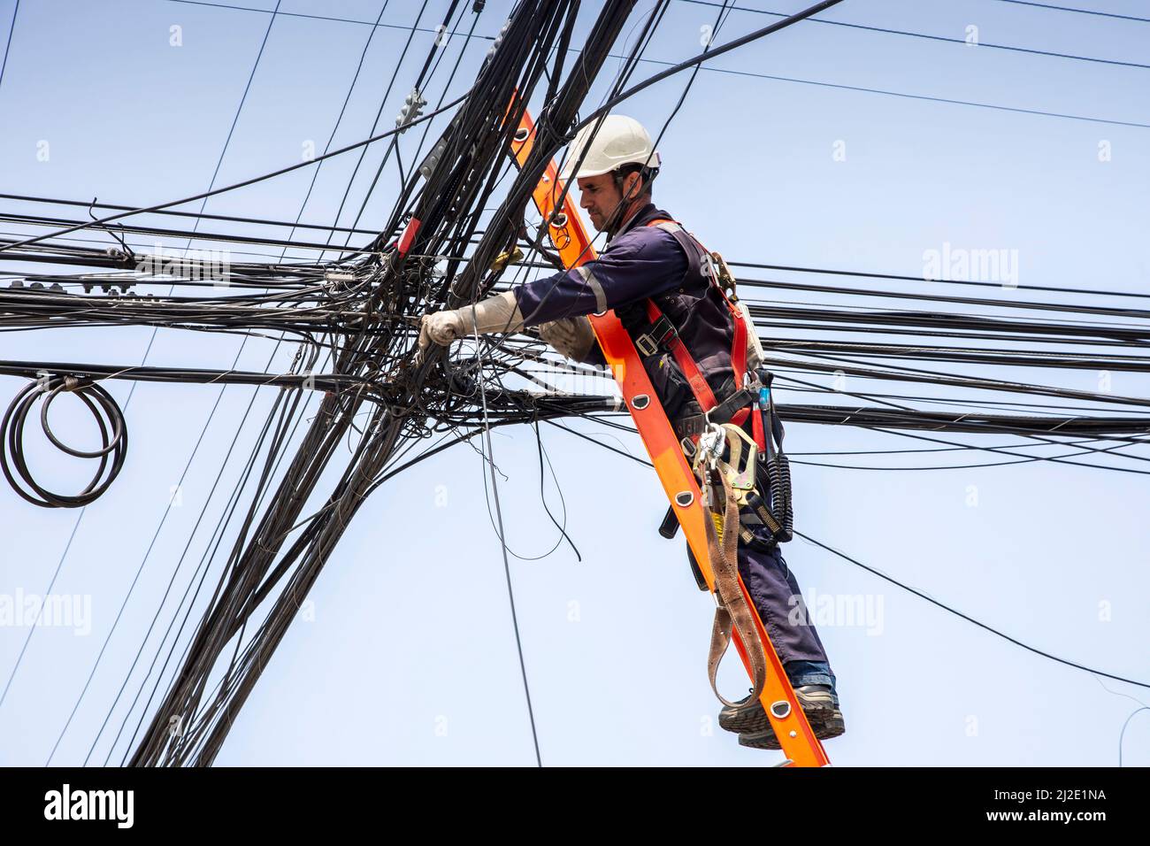 Chili 17-01-2020, Telefon- und Stromleitungen in Puerto Varas, wo ein Techniker eine der Leitungen repariert. Stockfoto