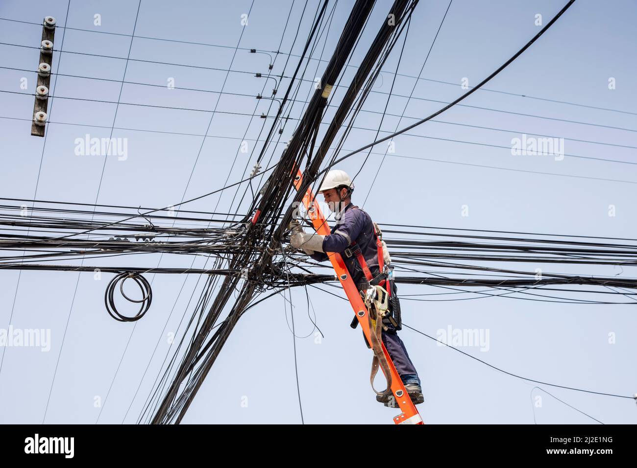 Chili 17-01-2020, Telefon- und Stromleitungen in Puerto Varas, wo ein Techniker eine der Leitungen repariert. Stockfoto