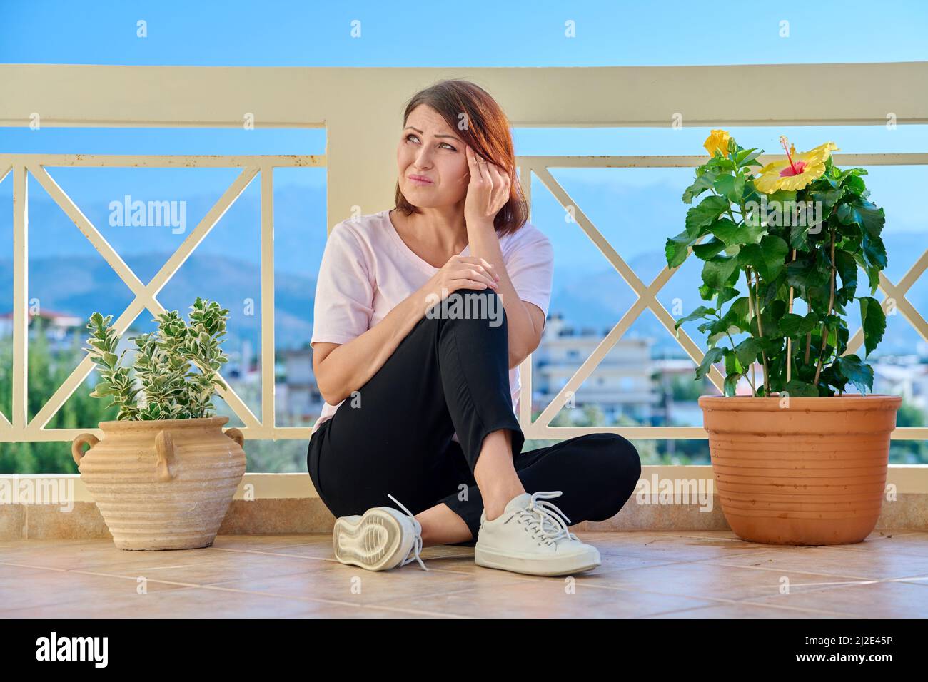 Traurige reife einsame Frau zu Hause auf der Terrasse Stockfoto