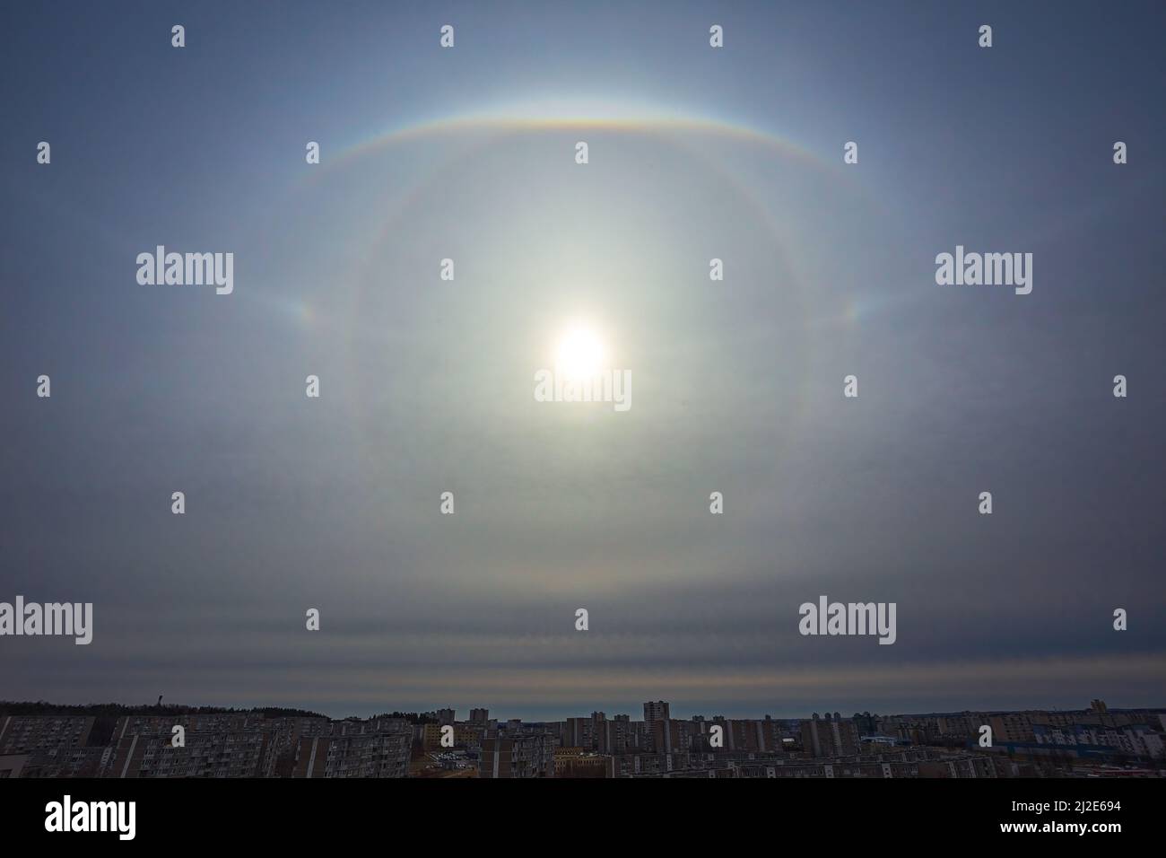 Sehr seltenes atmosphärisches Phänomen, genannt Sonnenhalo, verschiedene Sonnenhalos, die am Himmel in der Stadt erscheinen Stockfoto