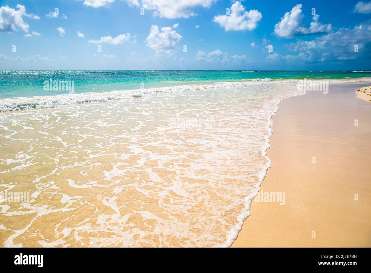 Schöner Strand mit sauberem Sand und kristallklarem Wasser, türkisfarbenem Meer und blauem Himmel in einem Traumurlaubsziel. Stockfoto