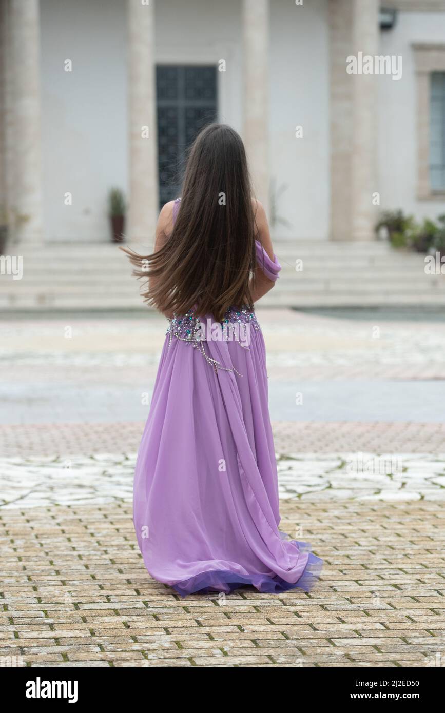 Junger Erwachsener, der einen orientalischen Tanz mit Bauch tanzt. Frau in orientalischem Kostüm tanzt im Freien Stockfoto