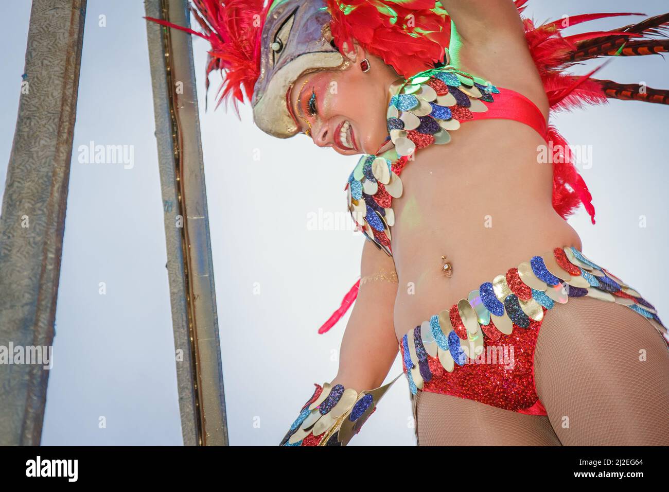 Portugal Karneval - Grupo Costa de Prata - Ovar 2016 Karnevalsparade in Ovar. Junge lächelnde Frau, die in einem rot-gefiederten Kostüm im brasilianischen Stil auftrat. Stockfoto