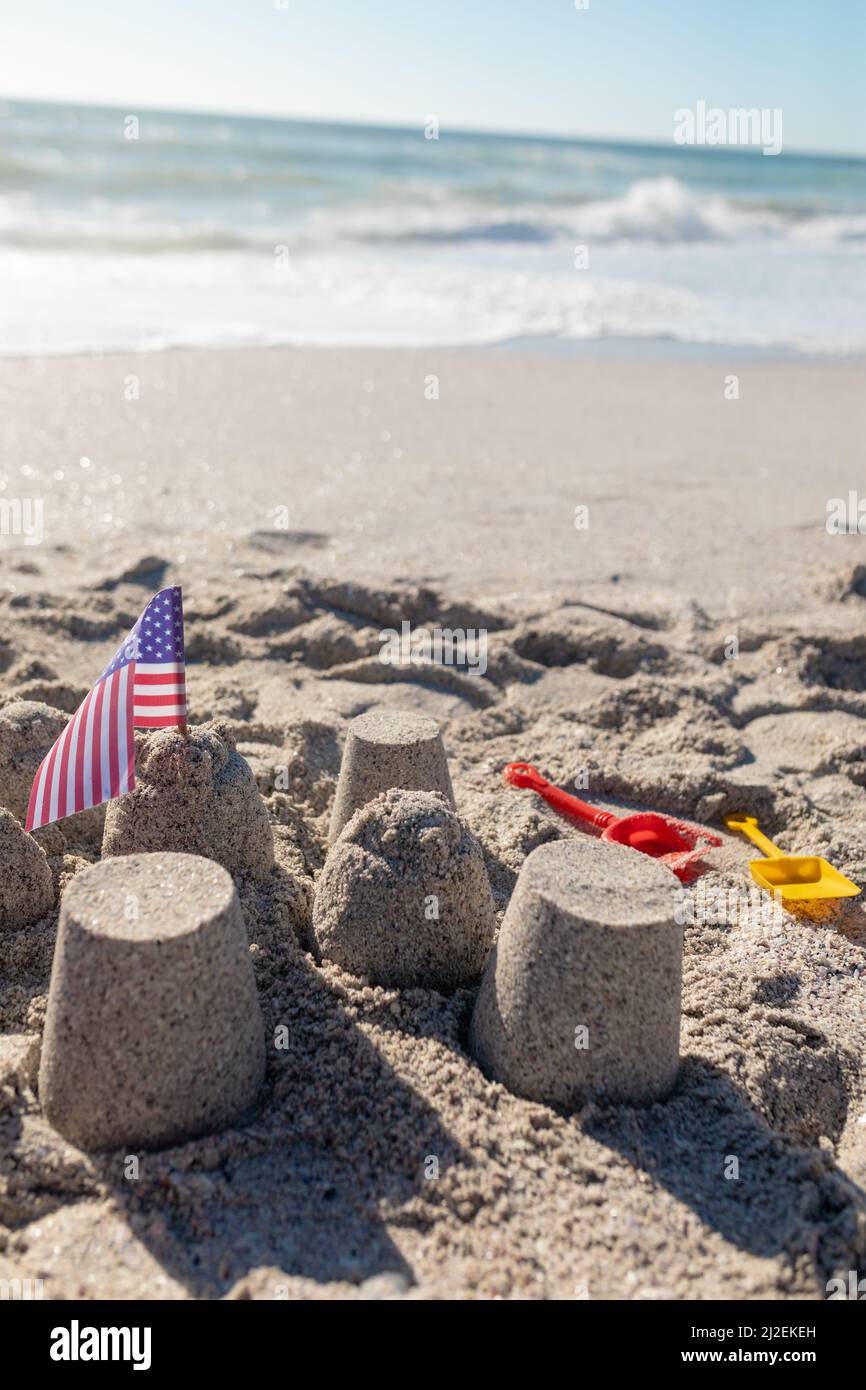 Amerika-Flagge mit Sandburg am Strand an sonnigen Tagen Stockfoto