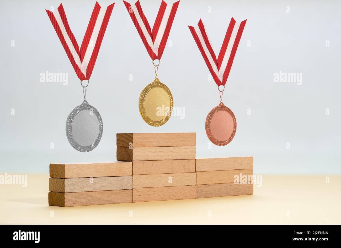 Plattform aus Holzblöcken und goldenen Silber- und Bronzemedaillen als Symbol der ersten zweiten und dritten Sieger. Stockfoto